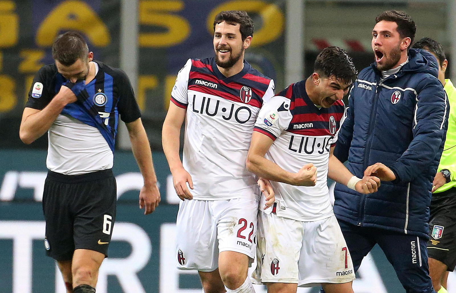 Stefan De Vrij (i), del Inter, se lamenta mientras Mattia Destro (c) y Riccardo Orsolini celebran el truinfo del Bologna.