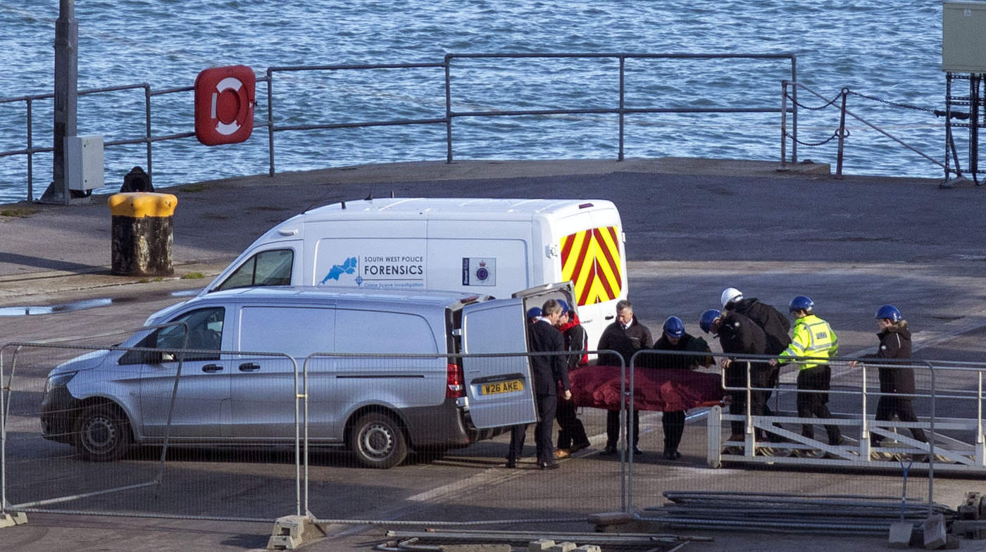 Personal de rescate traslada un cadáver en una camilla del barco especializado en búsquedas Geo Ocean III, en un muelle en Portland, Inglaterra.