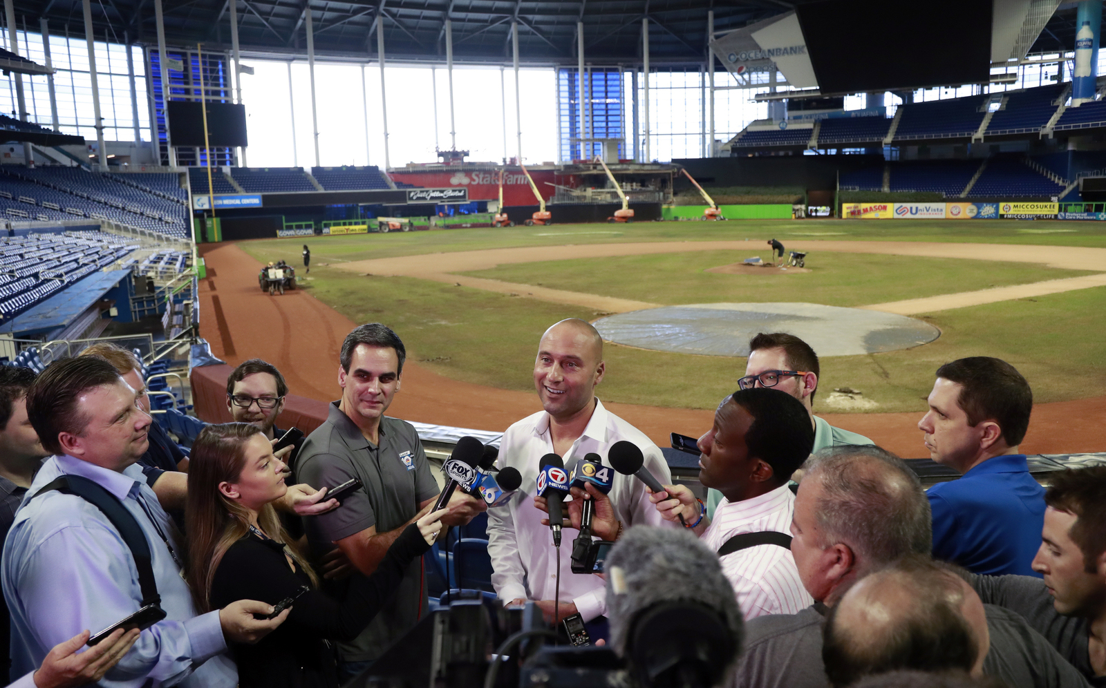 El director general de Marlins de Miami, Derek Jeter (c), habla con miembros de los medios de comunicación.