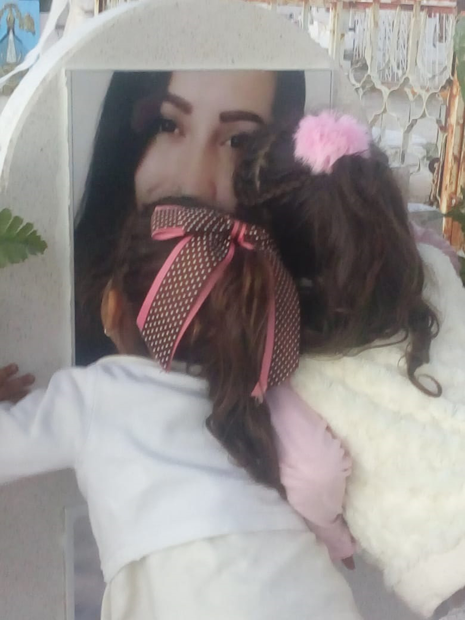 Las hijas de Dalia, Camila y Frida de, 4 y 5 años de edad respectivamente, besan la foto de su madre. (EL SIGLO DE TORREÓN)