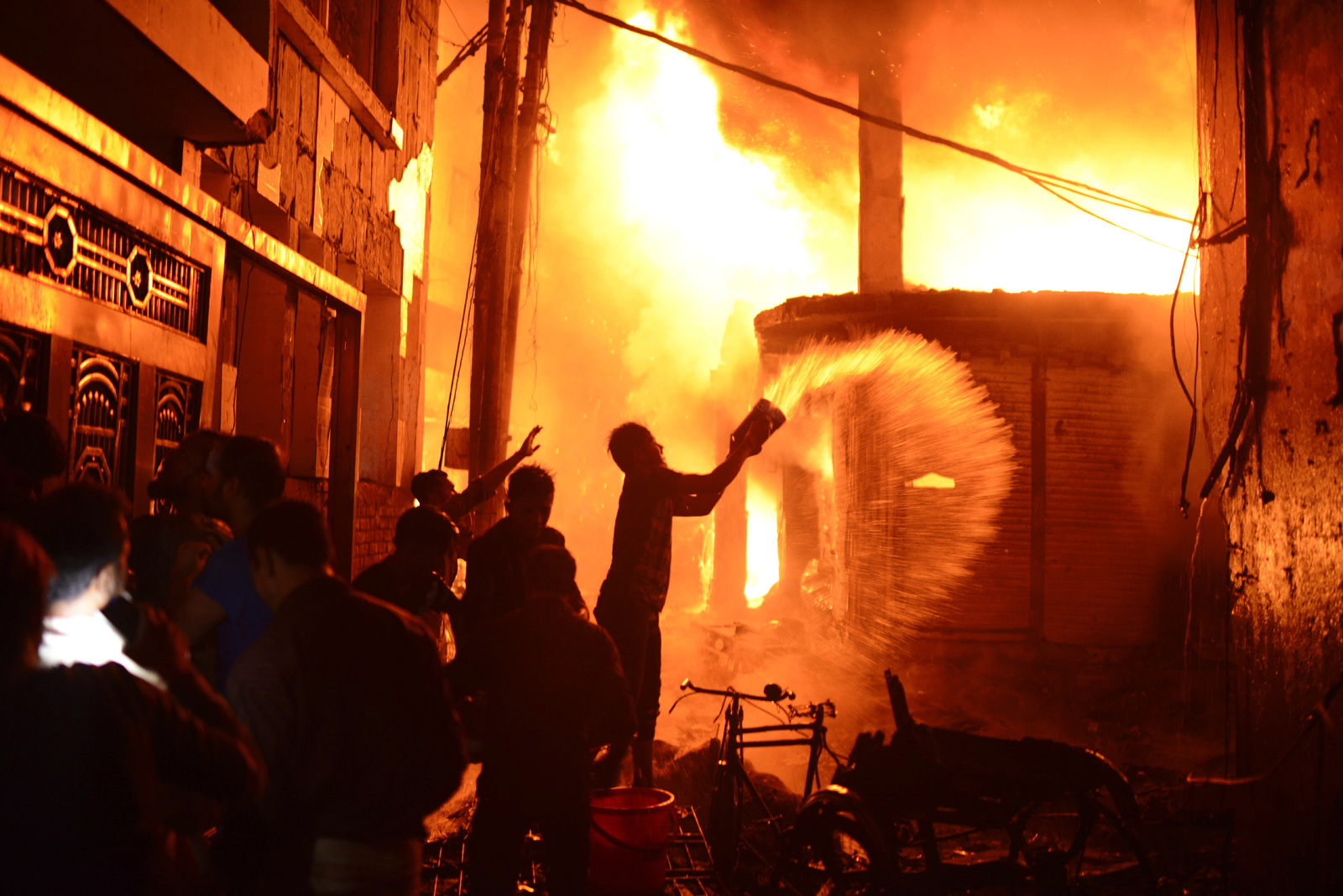 Complicado. Vecinos trataron de controlar el fuerte incendio que cobró la vida a 69 personas. (AP)