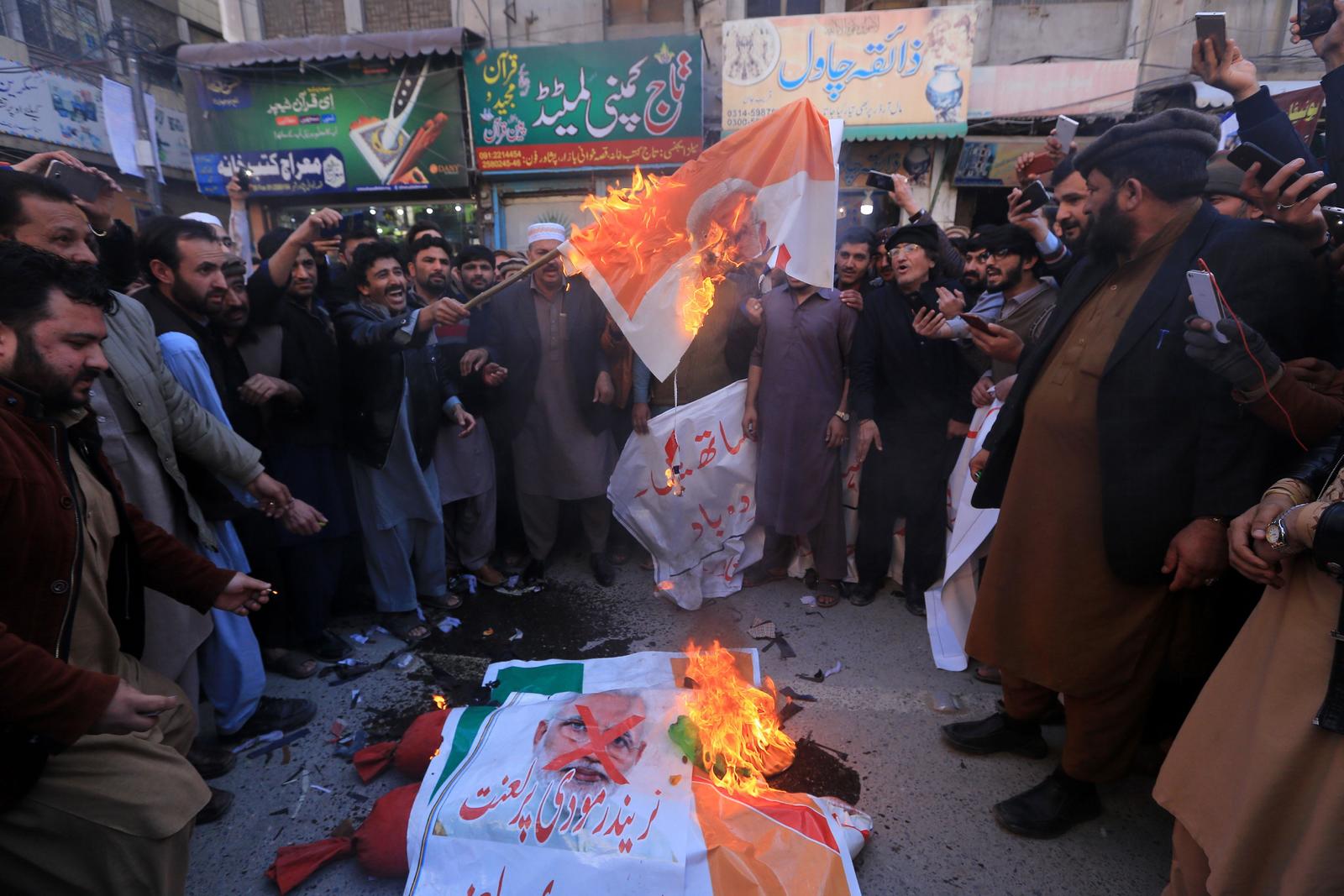Ciudadanos paquistaníes queman banderas con imágenes del primer ministro indio, Narendra Modi, durante una protesta. (EFE)