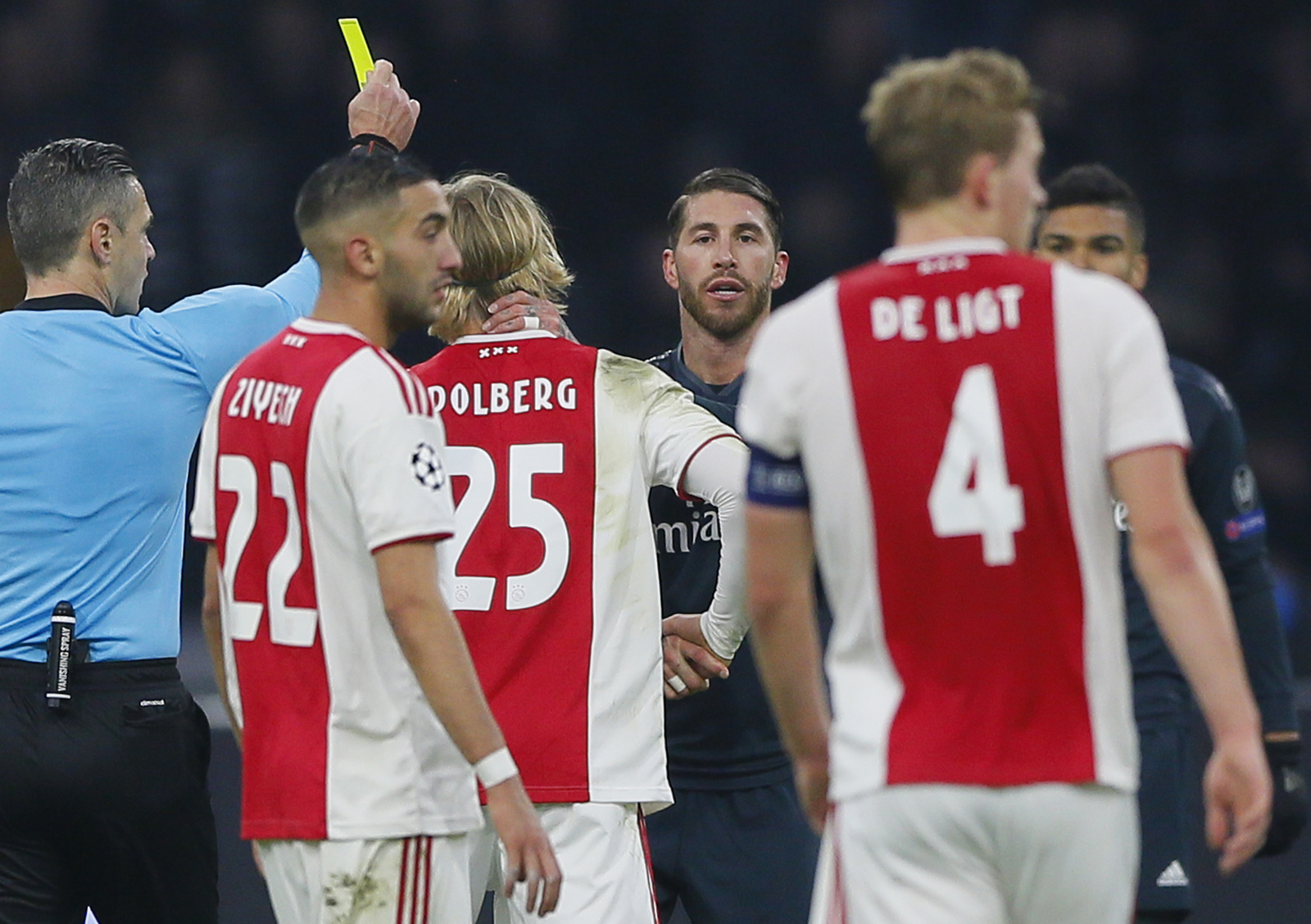 Damir Skomina (i), imponiendo una tarjeta amarilla al jugador del Real Madrid Sergio Ramos (al centro), después de una falta contra el jugador de Ajax Kasper Dolberg, durante su partido de la Champions League en Ámsterdam.