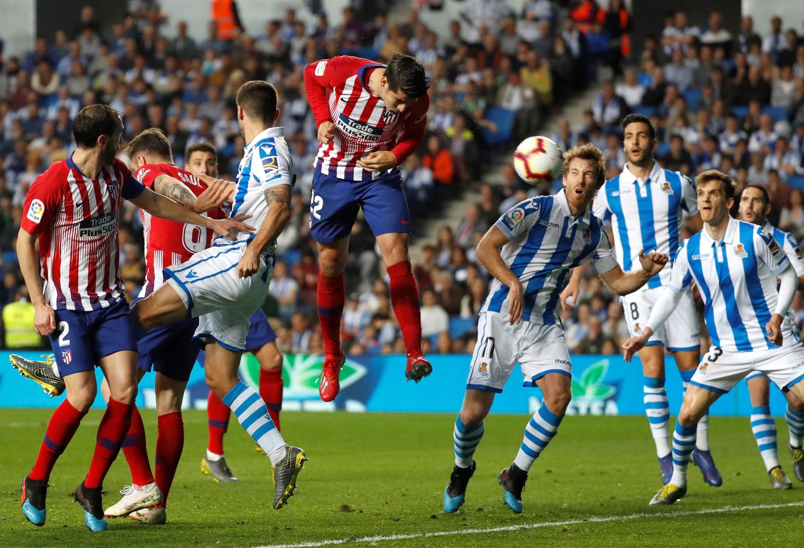 El delantero del Atlético de Madrid Álvaro Morata (c) remata de cabeza para conseguir su segundo gol y segundo del equipo rojiblanco.