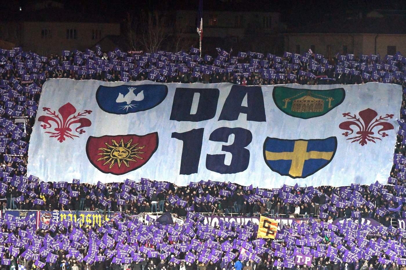 Los aficionados de la Fiorentina muestra una mega bandera con las iniciales de su eterno capitán Davide Astotri y su mítico número 13.