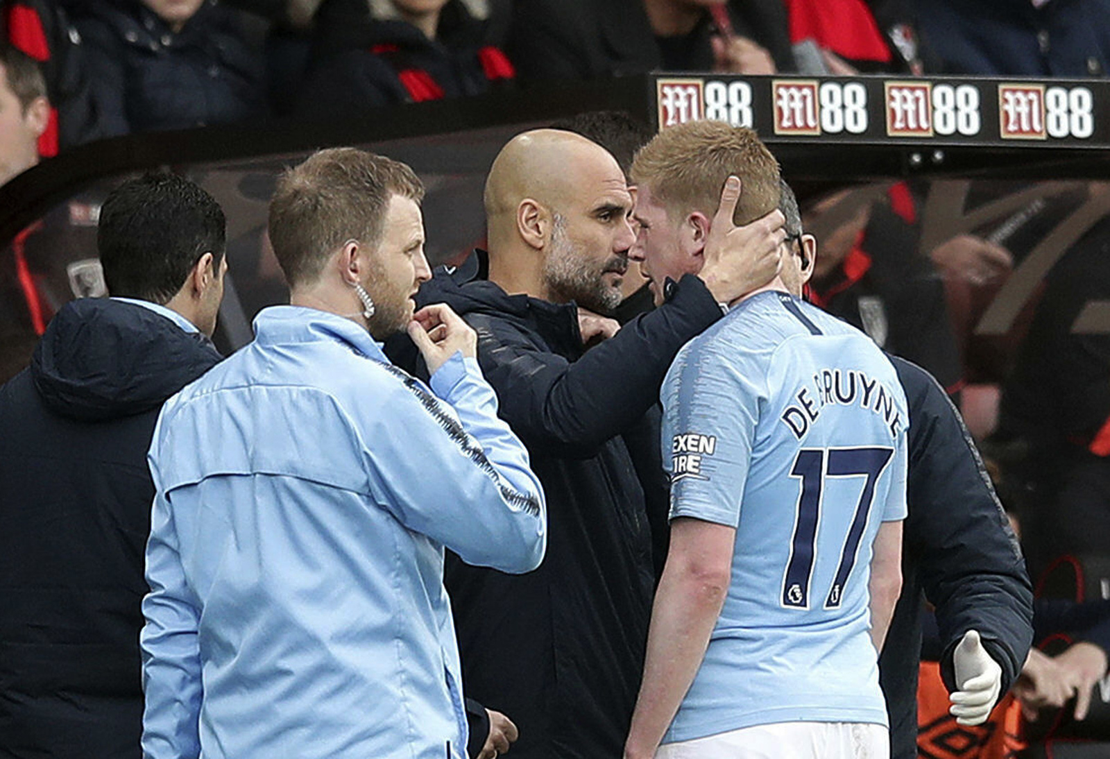 El técnico del Manchester City Pep Guardiola consuela a Kevin De Bruyne tras salir lesionado en el partido contra Bournemouth por la Liga.