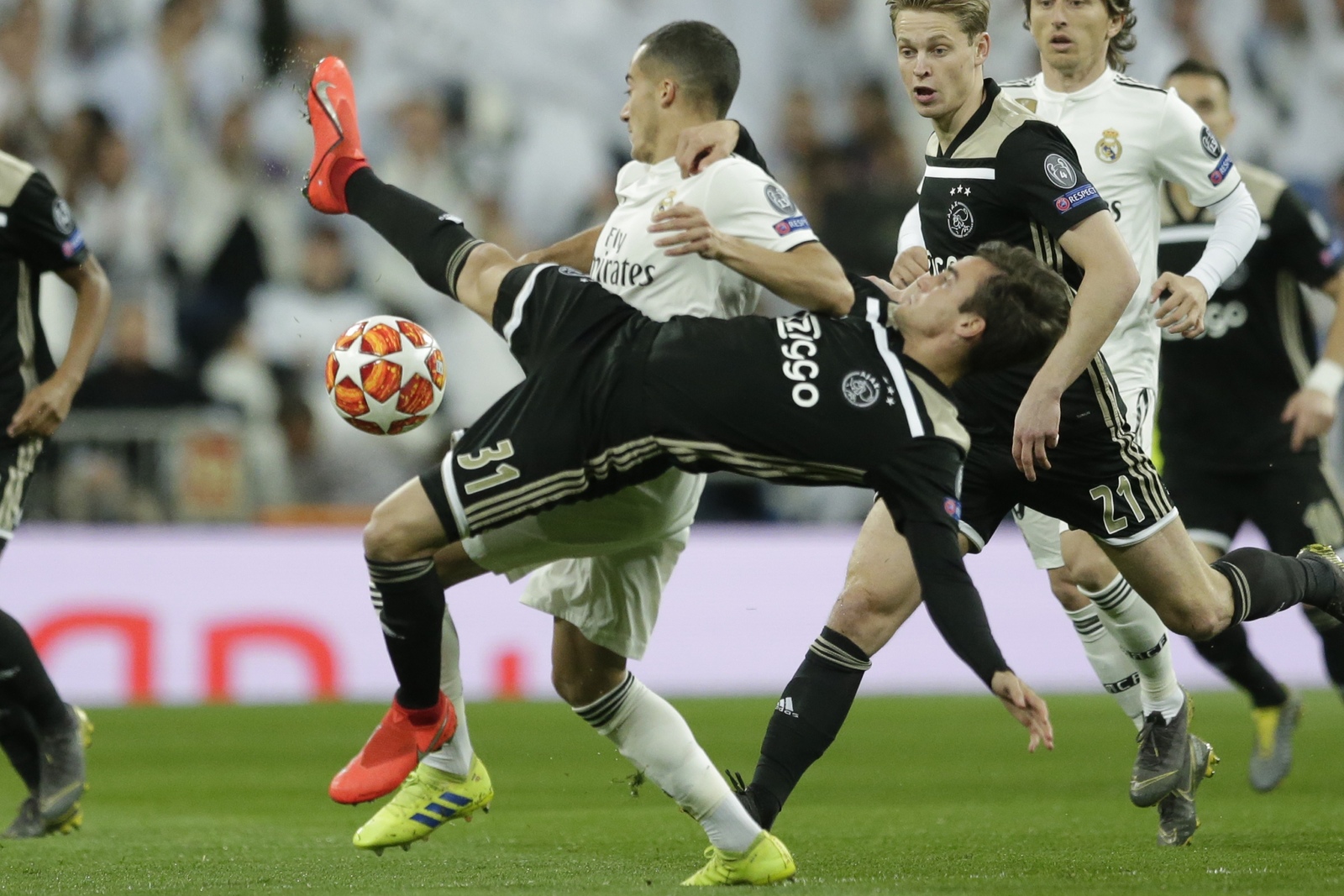 Lucas Vázquez (en camiseta blanca) del Real Madrid, y Nicolás Tagliafico, de Ajax, pugnan por un balón.
