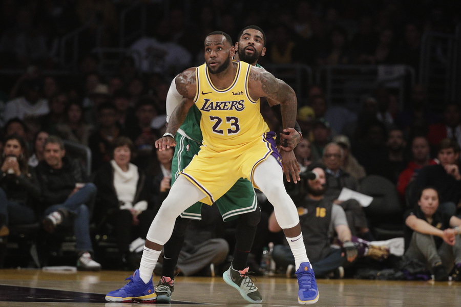 LeBron James, de los Lakers de Los Ángeles, trata de colocarse delante de Kyrie Irving, de los Celtics de Boston, en el encuentro del sábado 9 de marzo.
