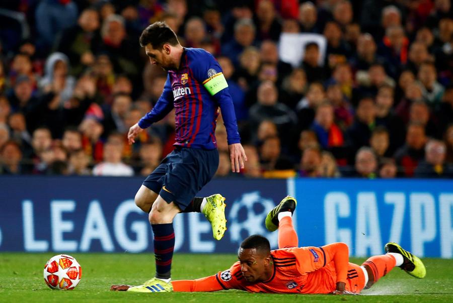 Lionel Messi (i) se lleva el balón ante el defensa brasileño del Olympique de Lyon, Fernando Marcal, durante el encuentro correspondiente a la vuelta de los octavos de final.