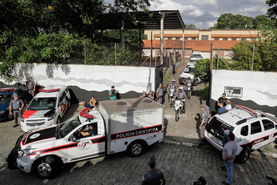Vehículos de los forenses y vehículos fúnebres salen con las víctimas de un tiroteo de la escuela pública secundaria Raúl Brasil ayer, en la región metropolitana de Sao Paulo. (EFE)