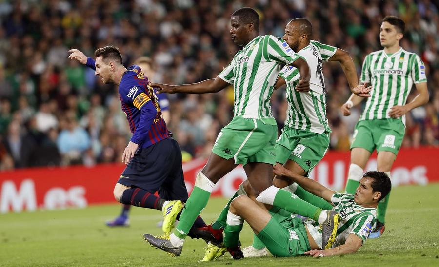El delantero argentino Lionel Messi (i), tras golpear el balón ante los jugadores del Real Betis consiguiendo el segundo gol del equipo blaugrana durante el encuentro.