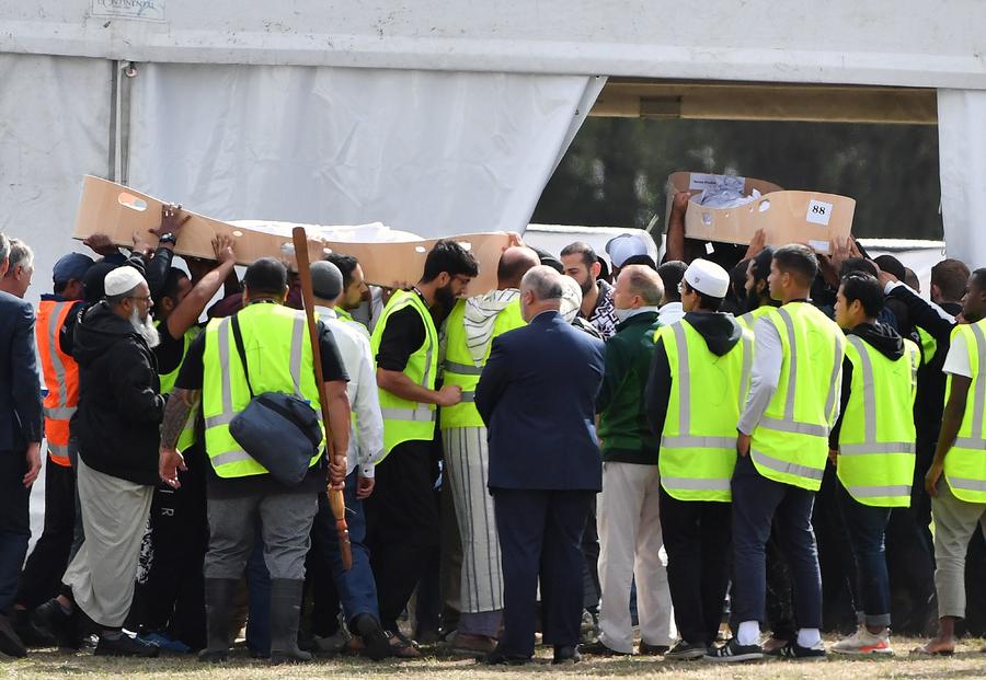 Decenas de personas sostienen los ataúdes de un padre y su hijo durante los primeros funerales de las víctimas de los tiroteos en la mezquita, ayer en el cementerio Memorial Park de Christchurch. (EFE)
