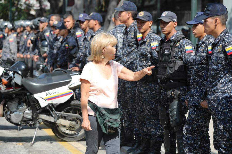 Una mujer habla a miembros de la Policía Nacional Bolivariana, en el lugar en donde manifestantes realizarían una marcha. (EFE)