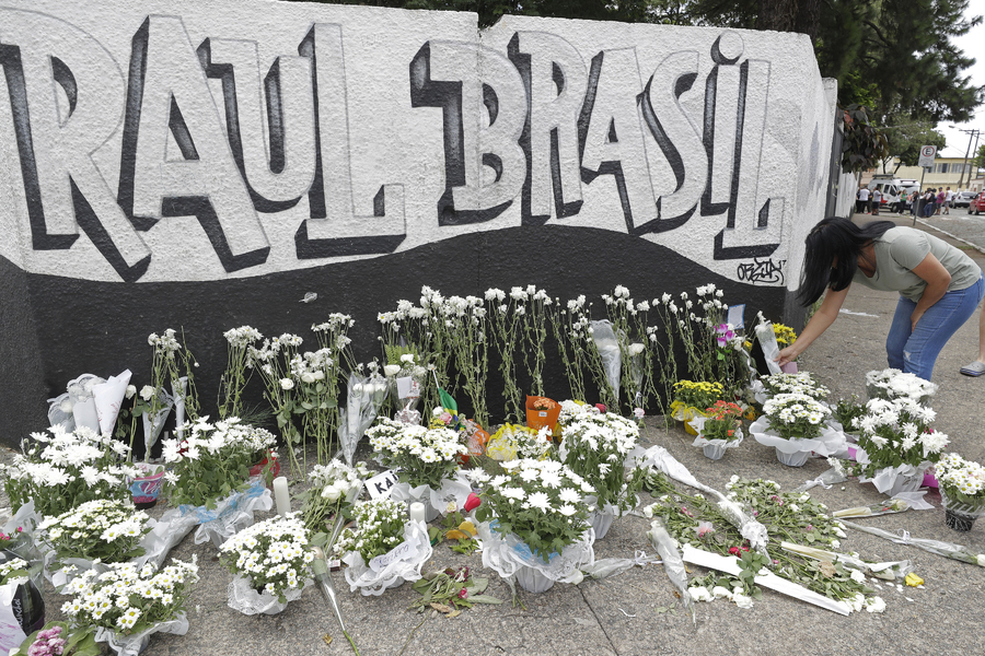Una mujer deja unas flores un día después de un tiroteo en la escuela pública Raul Brasil, en Suzano, Brasil. (AP)
