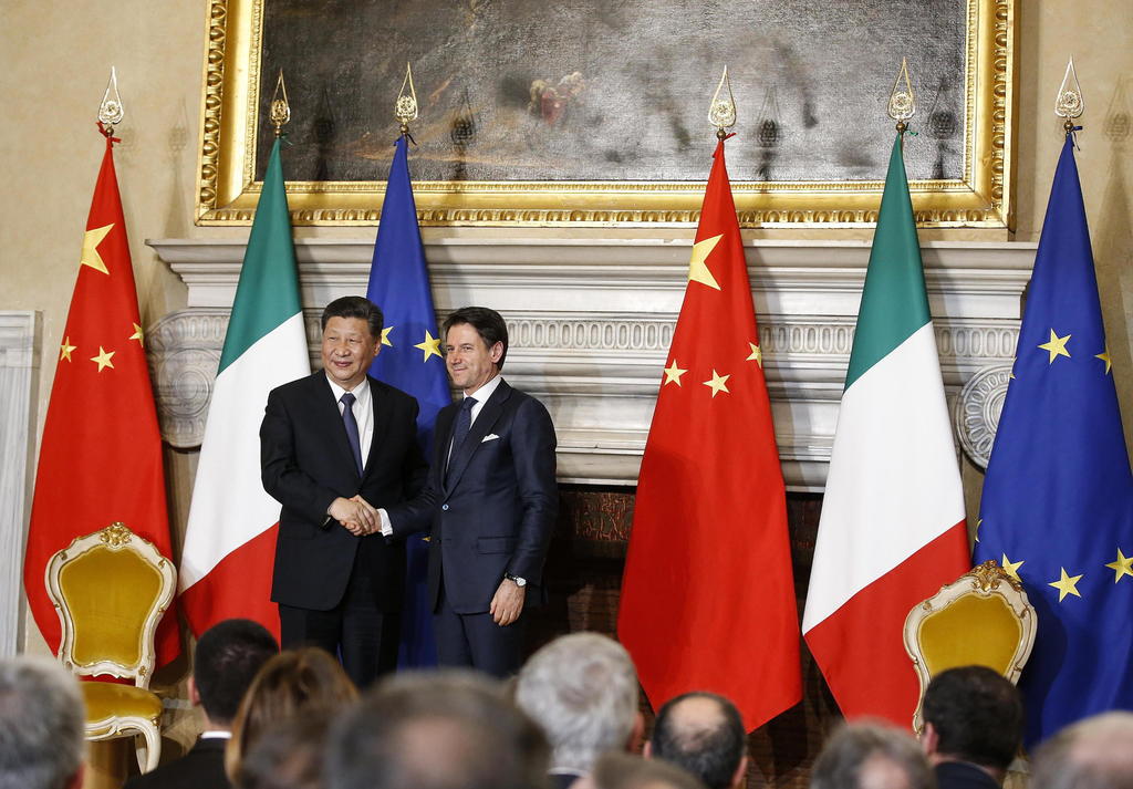 El primer ministro italiano Giuseppe Conte (Der.) le da la mano al presidente chino Xi Jinping.