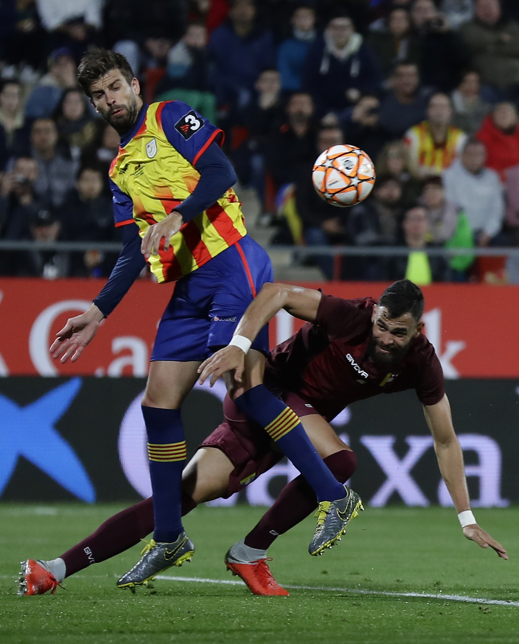 Gerard Piqué compite por el balón con el defensa de la selección de Venezuela, John Chancellor, durante un juego amistoso en el estadio Montilivi en Girona.