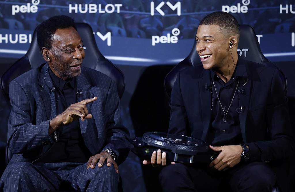 El legendario Pelé (i) y el joven astro del futbol francés Kylian Mbappé bromean durante un encuentro en París ayer.