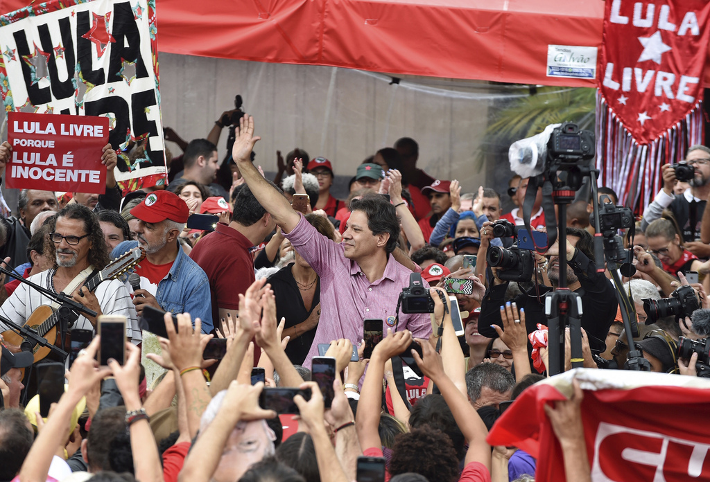 Fernando Haddad, del Partido de los Trabajadores, saluda en una protesta en el primer aniversario del encarcelamiento de Lula. (AP)