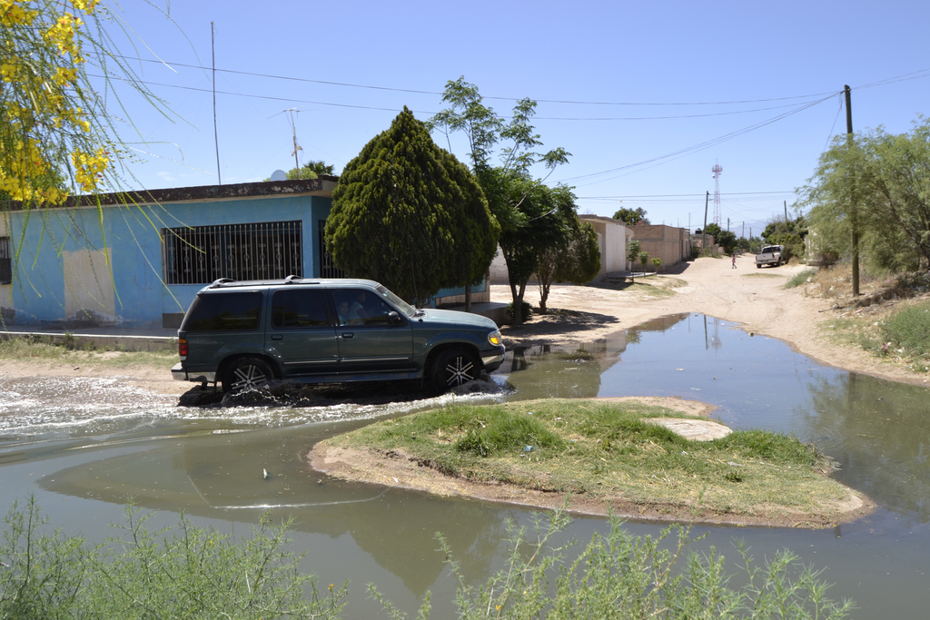 A pie o en vehículo, habitantes de Congregación Hidalgo tienen que pasar por las aguas negras. (EL SIGLO DE TORREÓN/EDITH GONZÁLEZ)