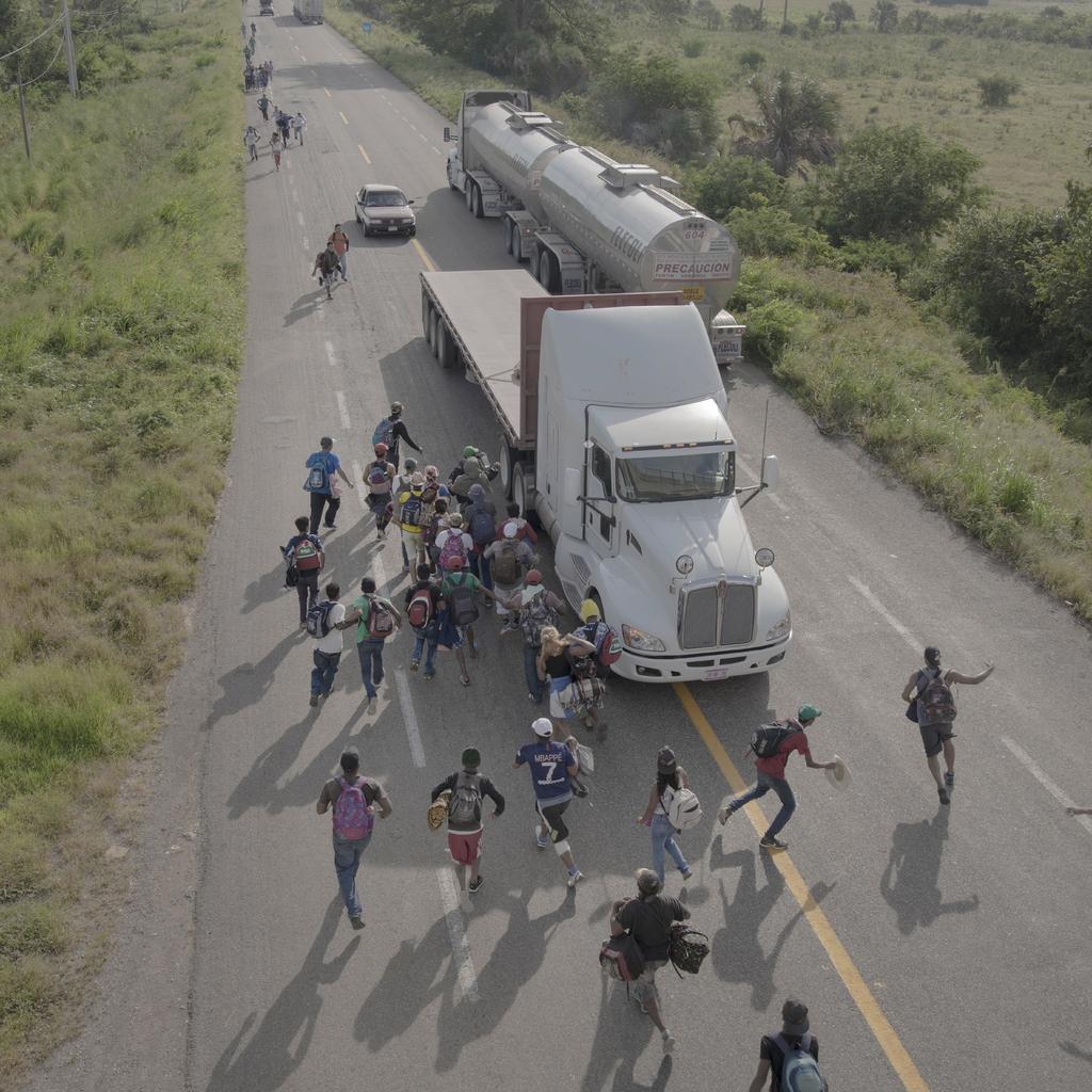 Varios migrantes corren hacia un camión que paró para llevarlos, fuera de Tapanatepec, Oaxaca. (WORLD PRESS PHOTO-EFE)