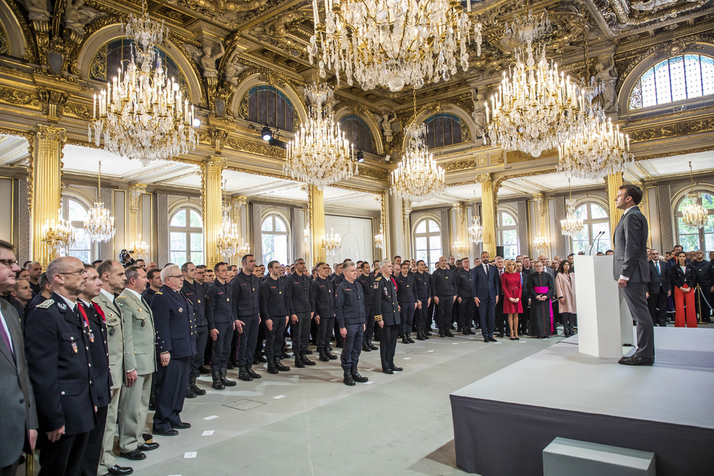 El presidente francés, Emmanuel Macron, honró a la brigada de bomberos y fuerzas de seguridad de París que ayudaron a extinguir el incendio en la catedral de Notre Dame. (AP)