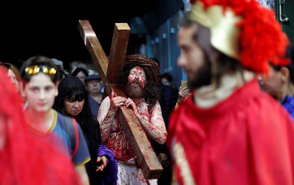 Los feligreses cargaron cruces de madera sobre sus hombros y corearon himnos para celebrar uno de los días más solemnes y sagrados del cristianismo. (EFE)