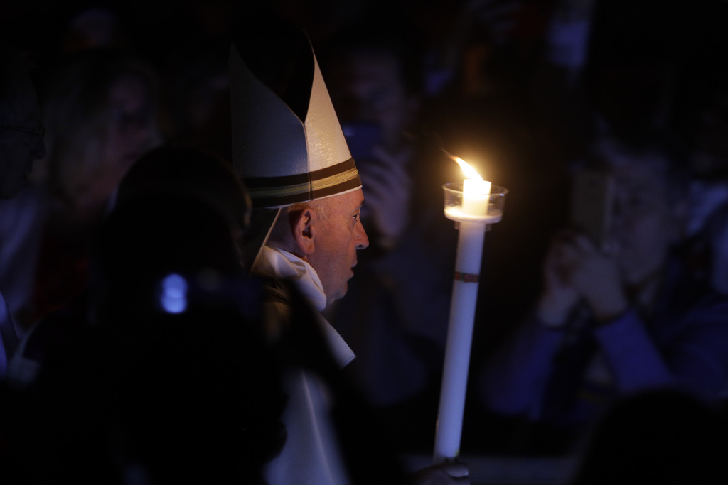 El papa Francisco sostiene una vela mientras preside una ceremonia solemne de vigila de Pascua en la Basílica de San Pedro.