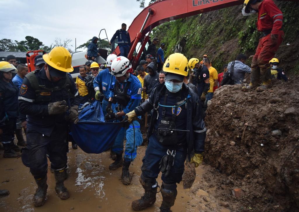 Miembros de equipos de rescate sacan el cuerpo de una persona, tras un deslizamiento de tierra en la vereda Portachuelo en el municipio de Rosas, Cauca. (EFE)