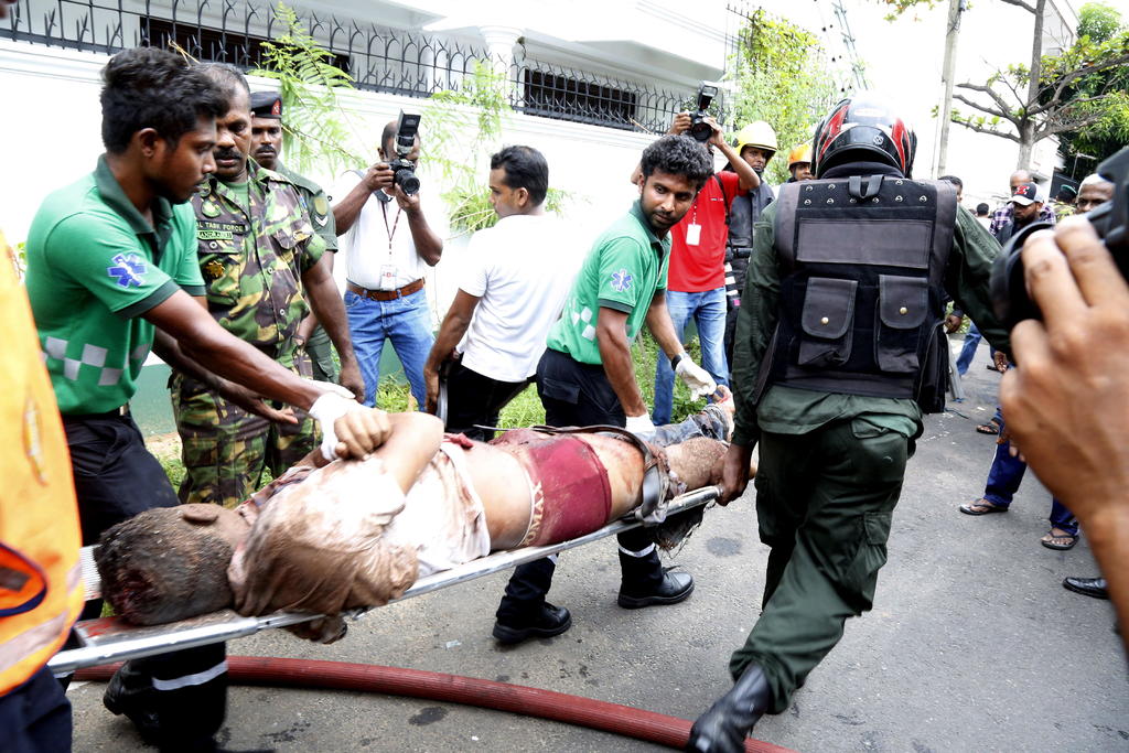 El personal de seguridad evacua a una víctima después de la reciente explosión en el área de Dematagoda en Colombo. (EFE y AP)