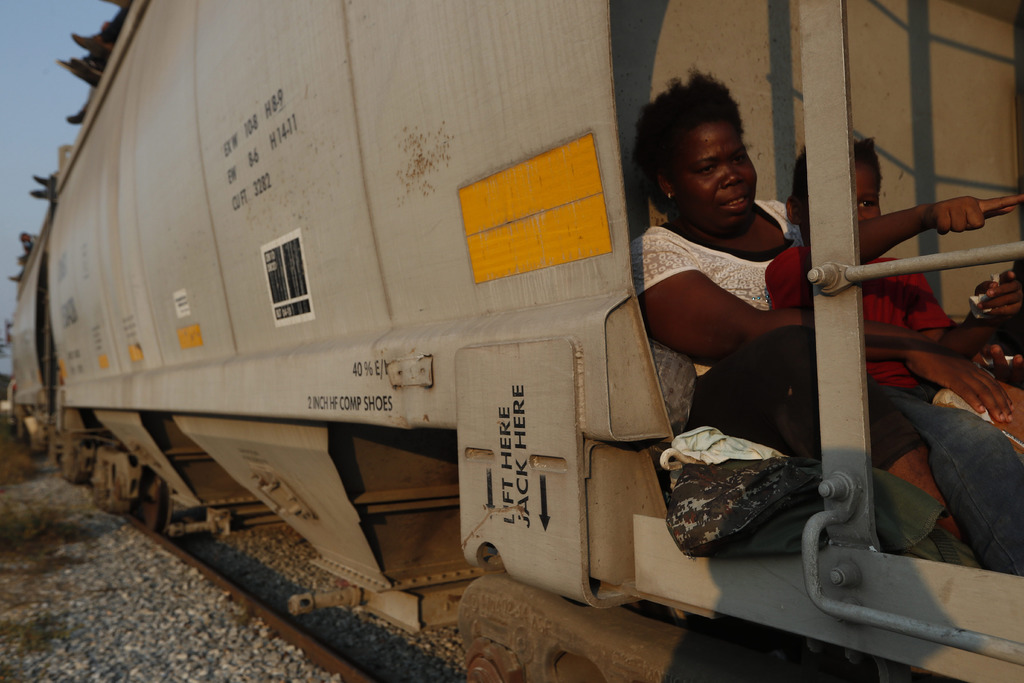 Una mujer y su hijo, de Roatán, Honduras, van sobre un tren de carga dirigido al norte rumbo a la frontera entre México y Estados Unidos, en Ixtepec. (AP)