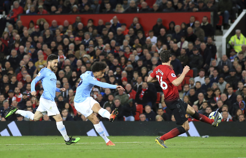 Leroy Sané dispara para marcar el segundo tanto del Manchester City en la victoria 2-0 sobre el United.