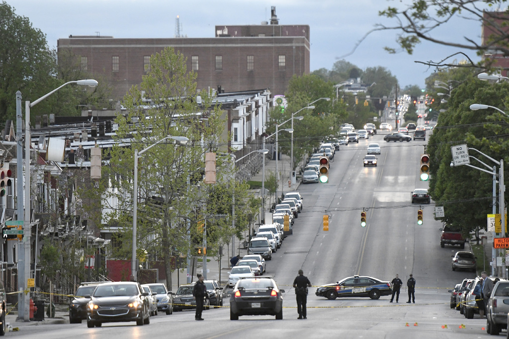 Policías trabajan cerca del lugar en el que, según las autoridades, varias personas fueron baleadas, al menos una de muerte, ayer en Baltimore. (EFE)