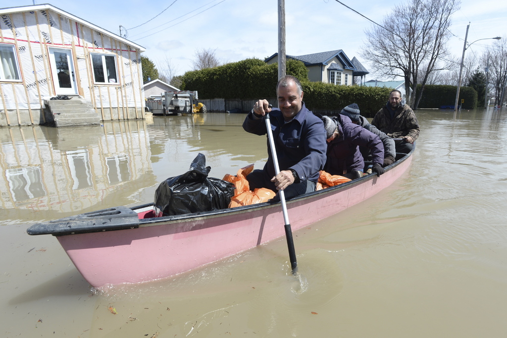 Residentes reman en una zona inundada en Ste-Marthe-sur-le-Lac, Quebec. (AGENCIAS)