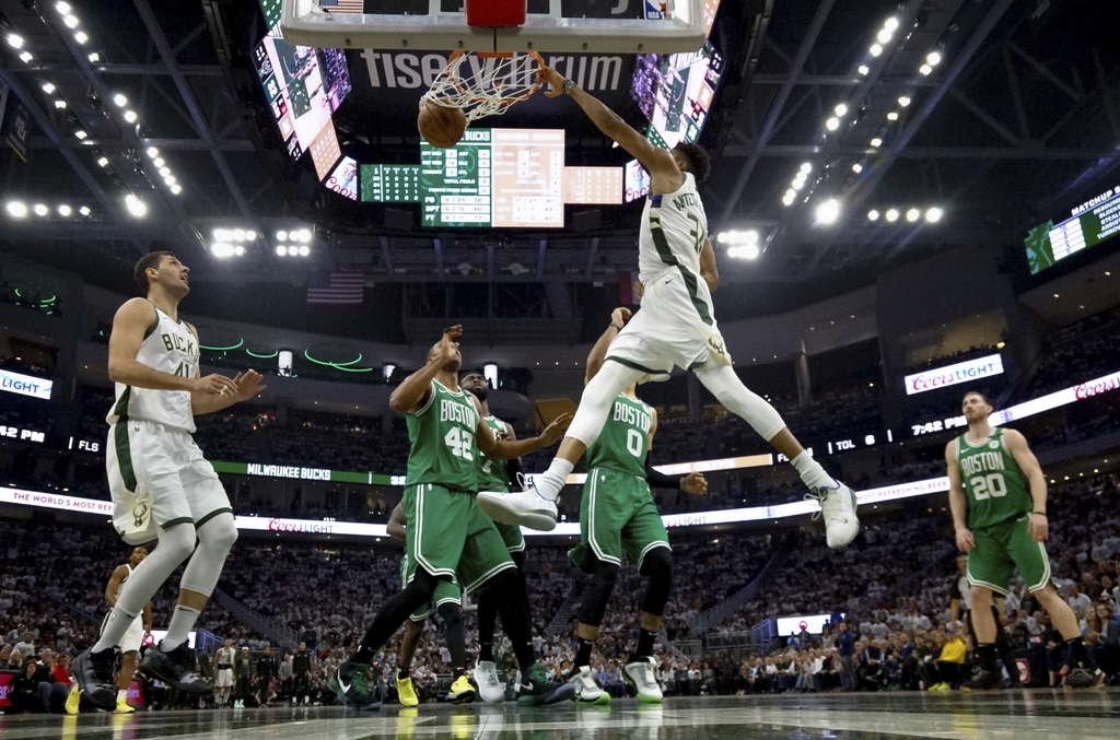 Giannis Antetokounmpo clava el balón, durante el juego de ayer en el que los Bucks derrotaron 123-102 a los Celtics de Boston.