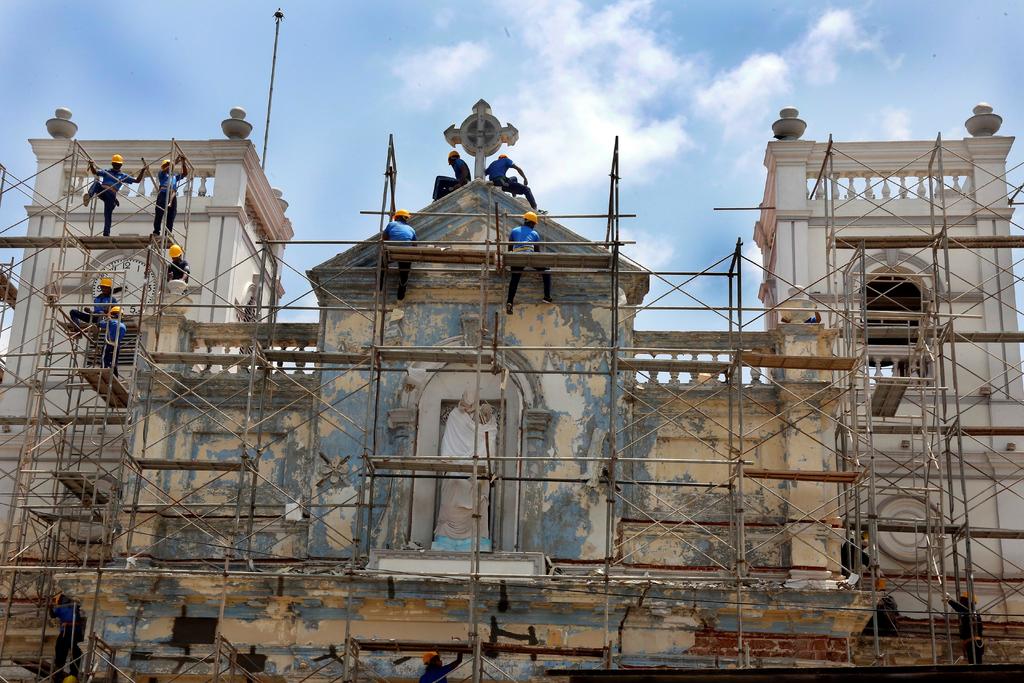 Integrantes de la Armada de Sri Lanka ayudan con las labores de restauración en la iglesia de San Antonio, parcialmente reabierta por primera vez desde los atentados este martes en Colombo. (EFE)