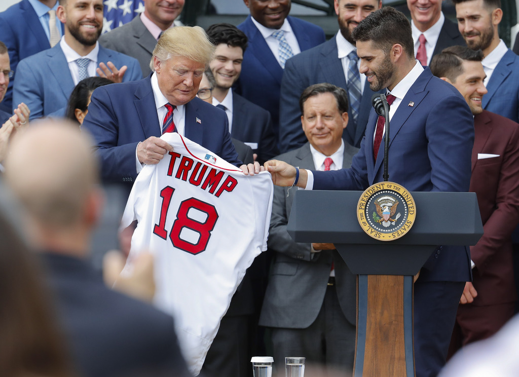 El beisbolista J. D. Martínez le regala un jersey a Donald Trump durante la visita de ayer de los Medias Rojas de Boston a la Casa Blanca, a la que no asistieron Alex Cora y varios jugadores de raza negra. (AP)