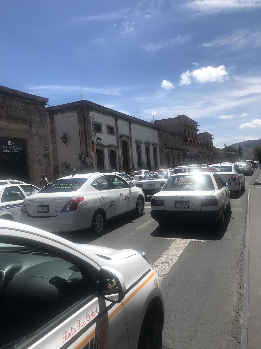 Por lo menos 300 taxistas con sus unidades marcharon este lunes en Morelia, en contra de las plataformas digitales que ofrecen servicio de autotransporte en la capital del estado y otros puntos de Michoacán. (TWITTER/@itzyoa)