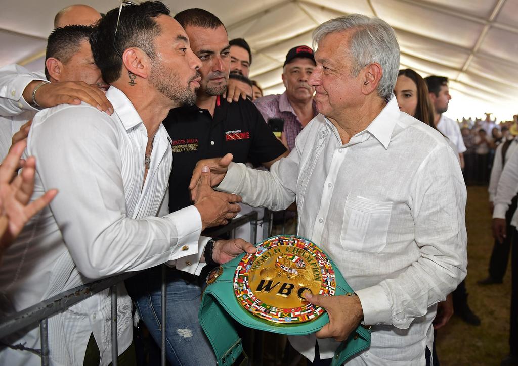El presidente Andrés Manuel López Obrador (d), mientras recibe un cinturón del excampeón Fernando Montiel. (ARCHIVO)