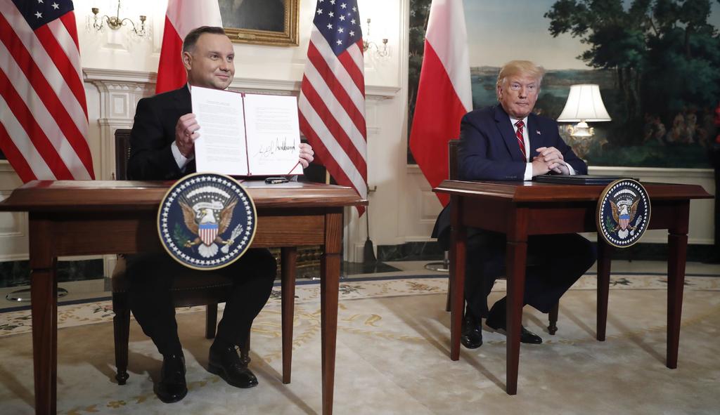 El presidente polaco, Andrzej Duda, y su homólogo de EUA, Donald Trump, firman acuerdo bilateral durante reunión. (EFE)