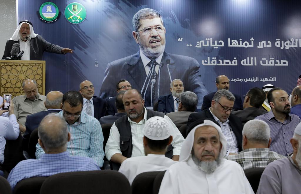 Varios hombres presentan sus condolencias ante el fallecimiento del expresidente egipcio Mohamed Morsi, este martes en la sede del Frente de Acción Islámica, en Amán, Jordania. (EFE)