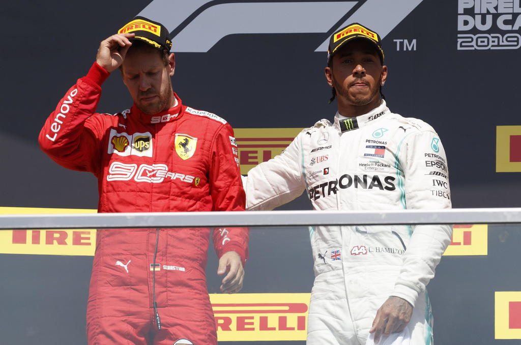 Sebastian Vettel -en rojo- fue sancionado y perdió en Canadá ante Lewis Hamilton -en blanco-. (AGENCIA)