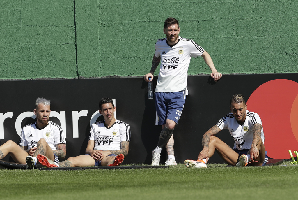 Nicolás Otamendi (i), Ángel Di María, Lionel Messi (de pie) y Roberto Pereyra durante un descanso en un práctica de Argentina. (AP)