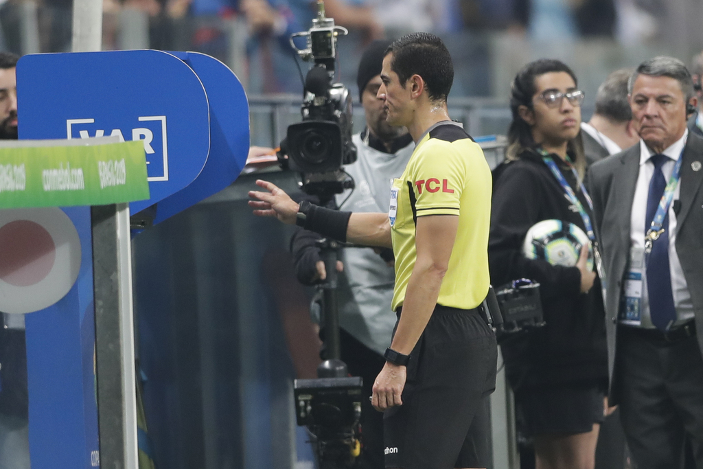 El árbitro Andrés Rojas observa el monitor del VAR durante un partido de la Copa América entre Uruguay y Japón. (AP)