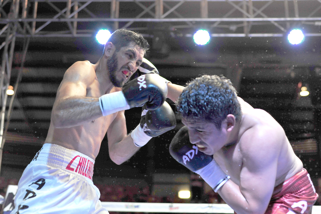 El boxeador de Gómez Palacio (izq.) utilizó toda su experiencia para derrotar a un adversario que lo supera en alcance y estatura. (ARCHIVO)