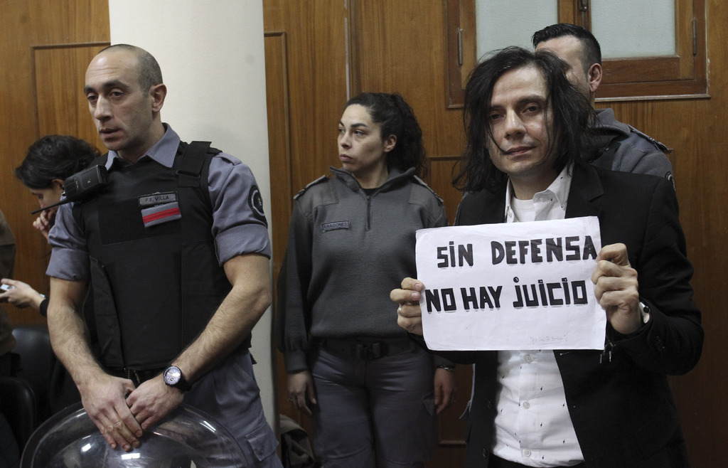 Sentenciado. Cristian Aldana, vocalista de la banda El Otro Yo, posa con un cartel que dice 'Sin defensa no hay juicio'. (ARCHIVO)