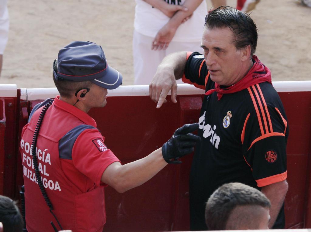 En España. El actor, director y productor estadounidense Daniel Baldwin (derecha) recibe indicaciones de un policía foral en la Plaza de Toros.