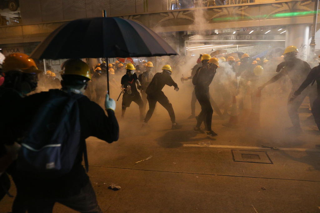 Decenas de personas se enfrentan a la policía durante una protesta contra la brutalidad policial en Hong Kong (China), ayer. (EFE)
