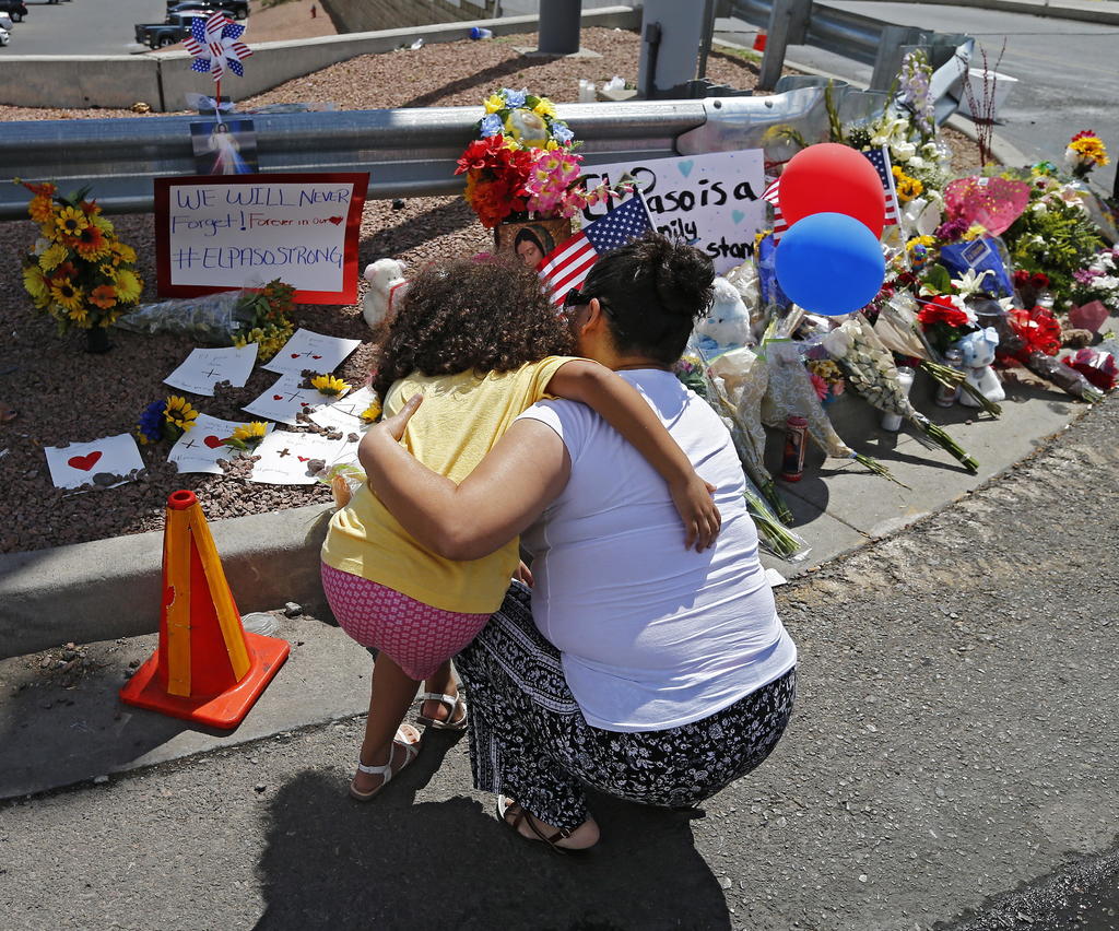 Sin consuelo. Una mujer consuela a una niña mientras se arrodilla frente a un memorial por turnos a lo largo de la calle detrás de la escena de un tiroteo masivo en un Walmart en El Paso, Texas. (EFE)