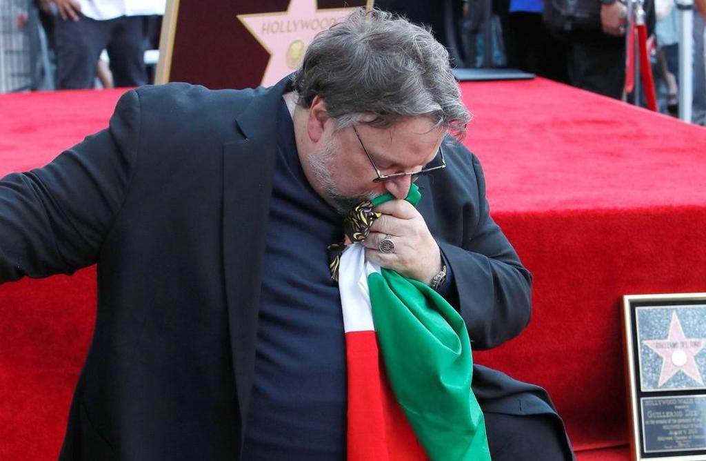 Entusiasmado. El cineasta Guillermo del Toro besa la bandera de México durante la entrega de su estrella en el Paseo de la Fama. (EFE)