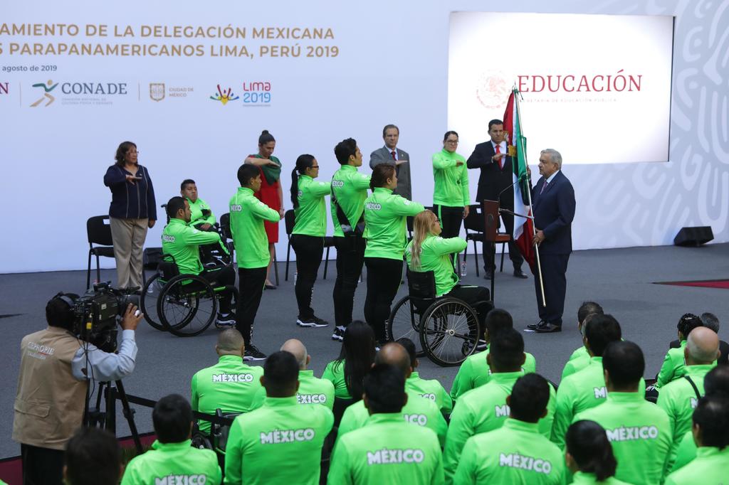 El presidente de México, Andrés Manuel López Obrador (d), entrega la bandera nacional a los deportistas que participarán en los Juegos Parapanamericanos de Lima 2019. (EFE)